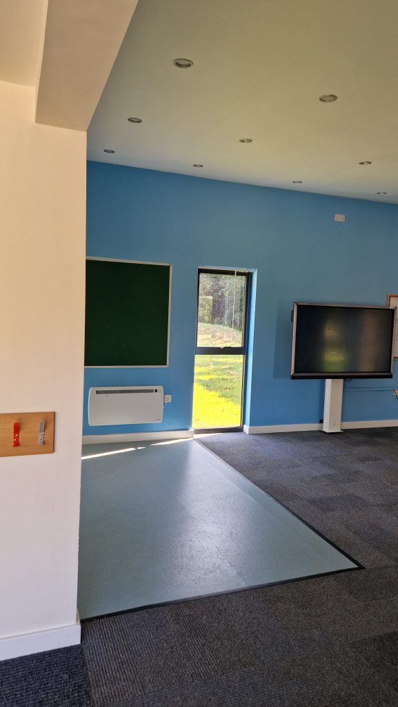 A room repainted in blue and white with a cream ceiling, a noticeboard and a tall window